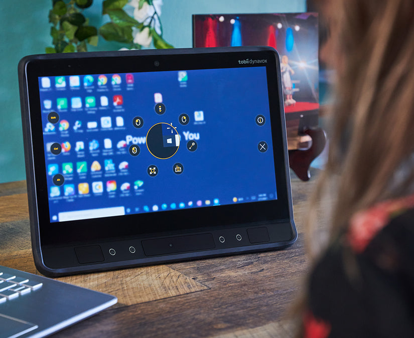 Mujer usando TD Control de Tobii Dynavox en un dispositivo generador de voz controlado con la mirada TD I-Series