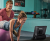 Mujer usando su dispositivo de tecnología de asistencia Tobii Dynavox TD I-Series en el gimnasio