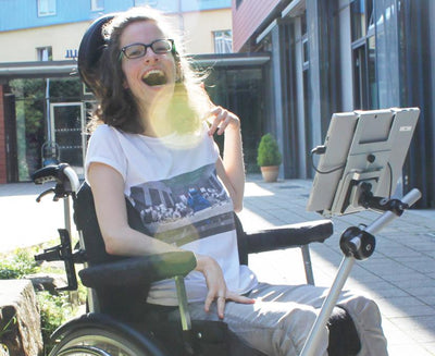Mujer joven usando su soporte Tobii Dynavox para PCEye fuera